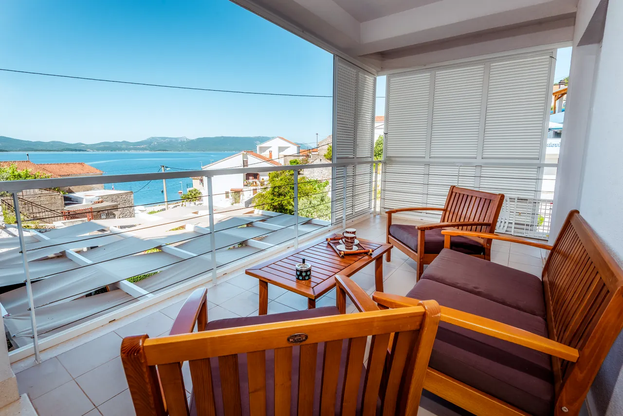 Balkon mit Holzsitzgarnitur und Meerblick