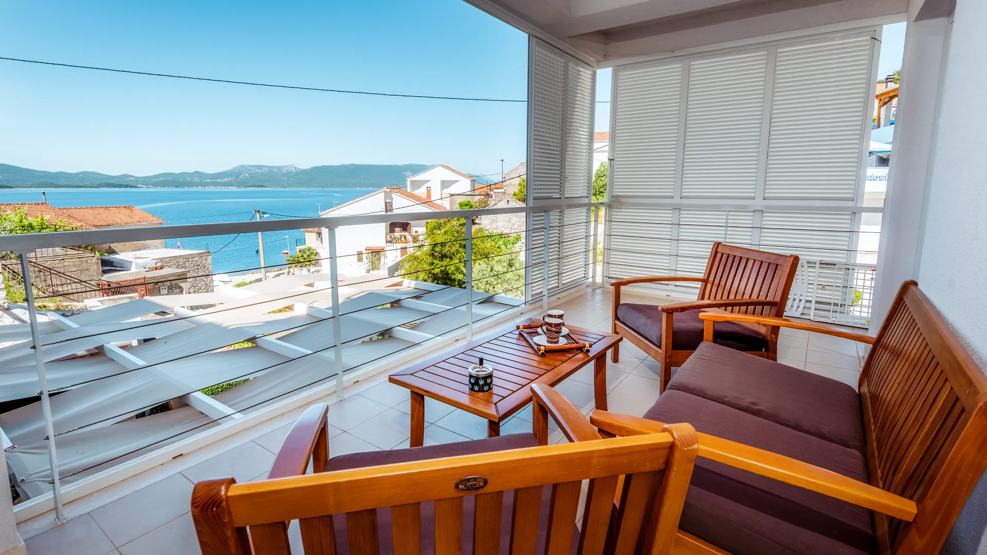 Balkon mit Holzsitzgarnitur und Meerblick