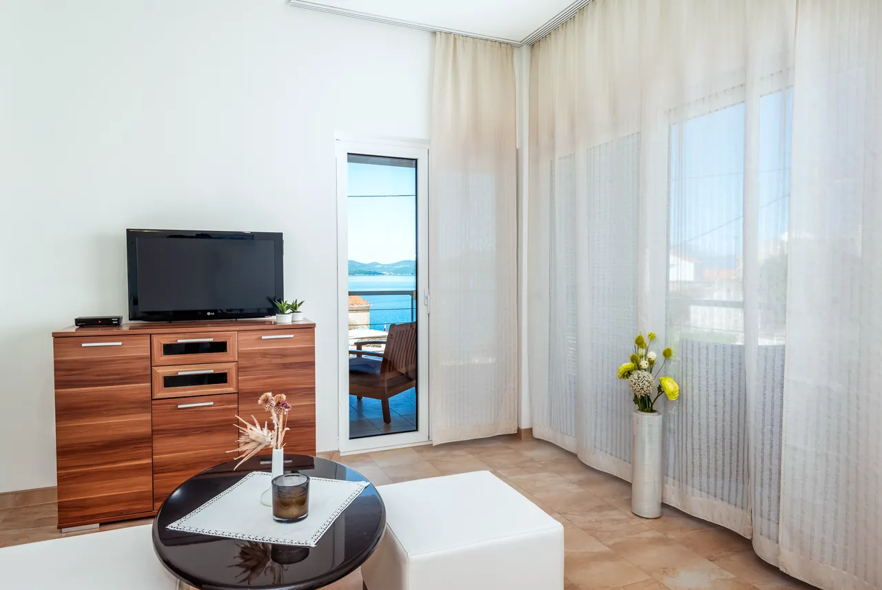 Wohnzimmer mit TV und Zugang zum Balkon