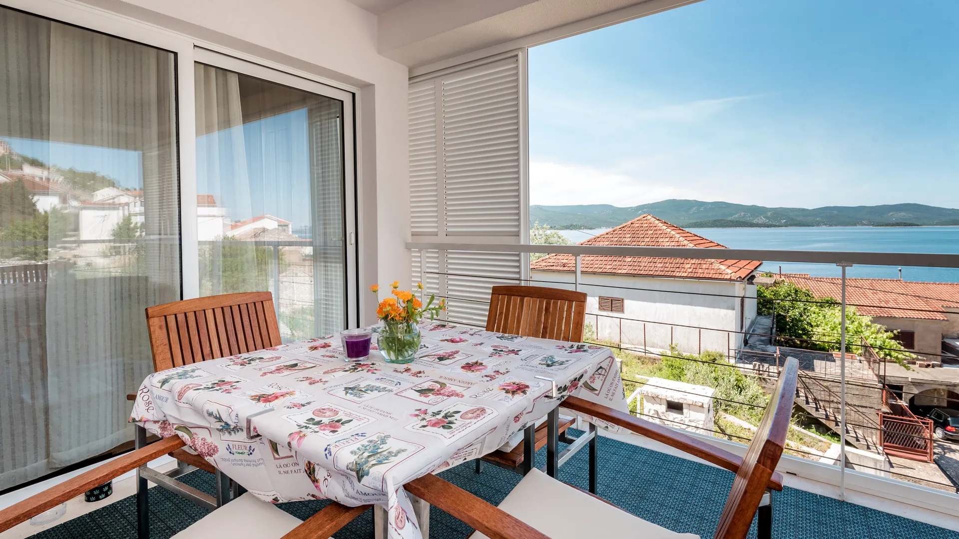 Überdachter Balkon mit Esstisch und Meerblick