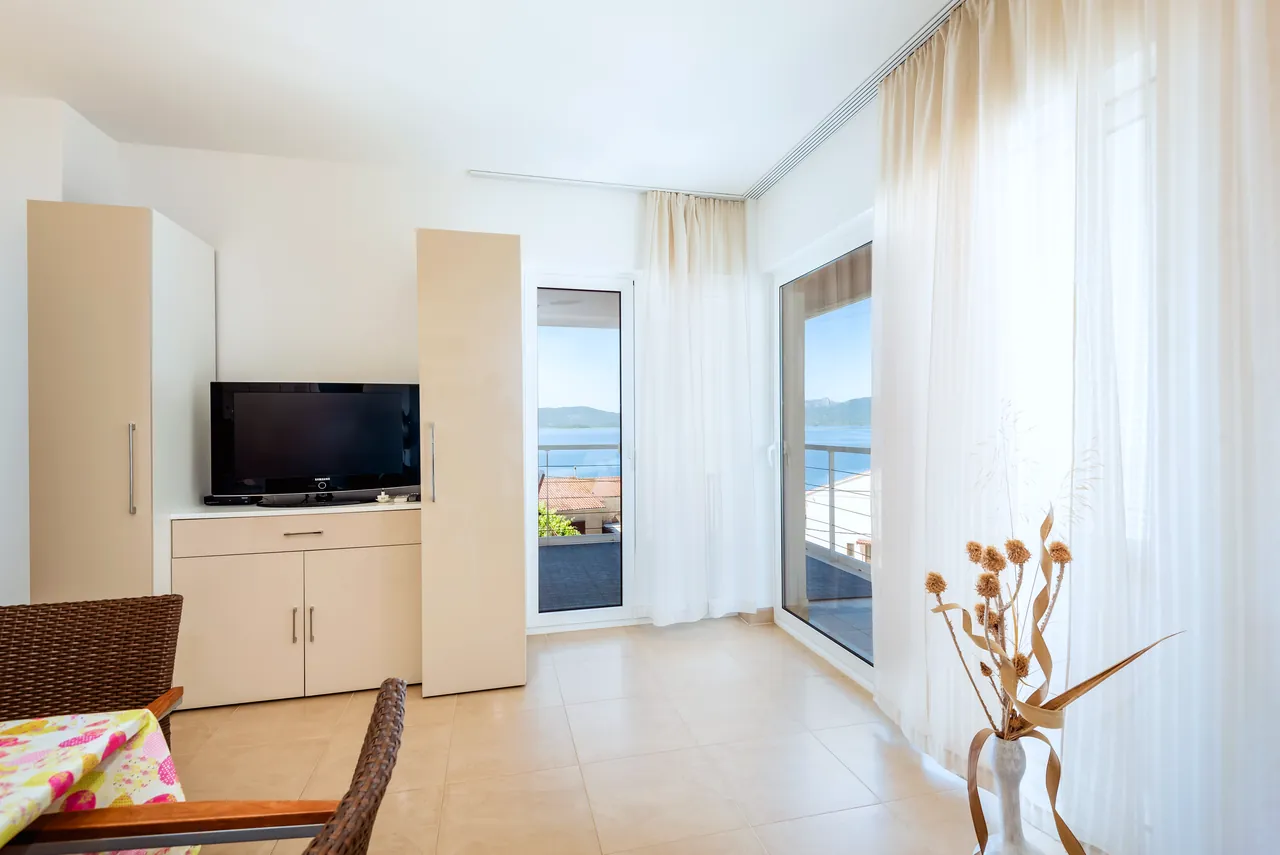 Wohnzimmer mit TV und Zugang zum Balkon