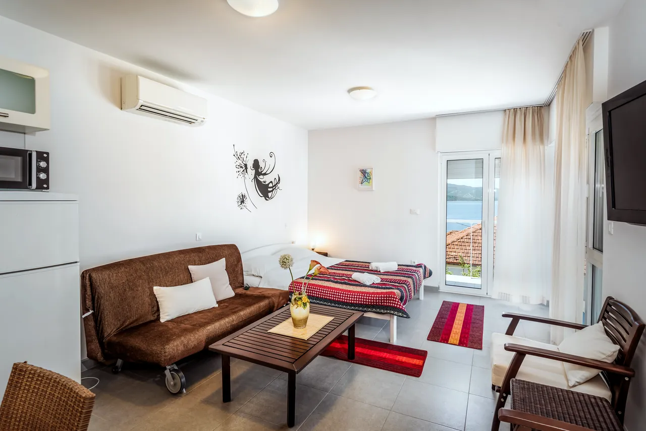 Studio: Wohnbereich mit Sofa und Doppelbett